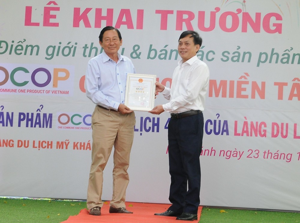 Phó Chủ tịch UBND thành phố Cần Thơ Nguyễn Ngọc Hè (phải) trao chứng nhận sản phẩm du lịch OCOP 4 sao đầu tiên ở ĐBSCL cho đại diện Làng du lịch Mỹ Khánh. 
