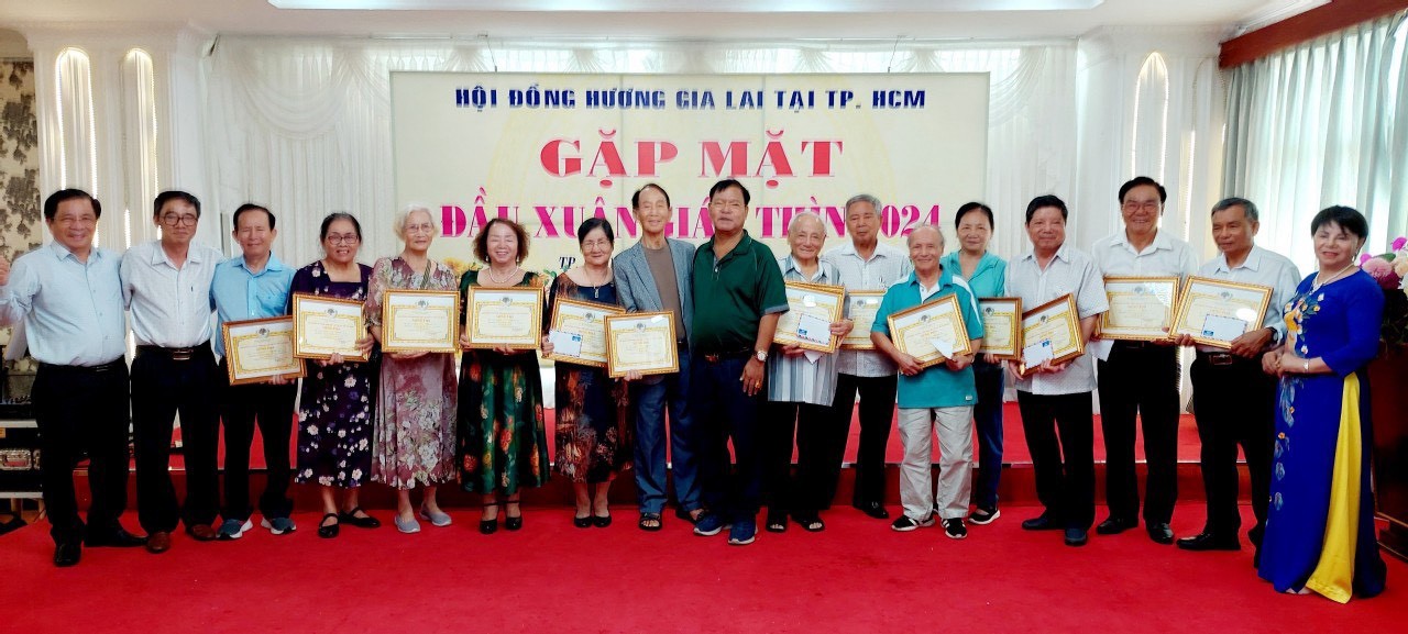 Ông Ksor Nham - Trưởng ban liên lạc Hội đồng hương Gia Lai tại TP.HCM (áo xanh ở giữa) trao tặng Giấy chứng nhận Người cao tuổi của Hội đồng hương Gia Lai