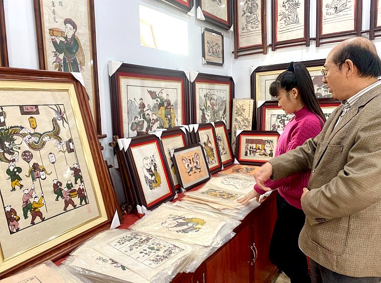 Ông Nguyễn Hữu Hoa đang giới thiệu cho khách tham quan những bức tranh ấn tượng 